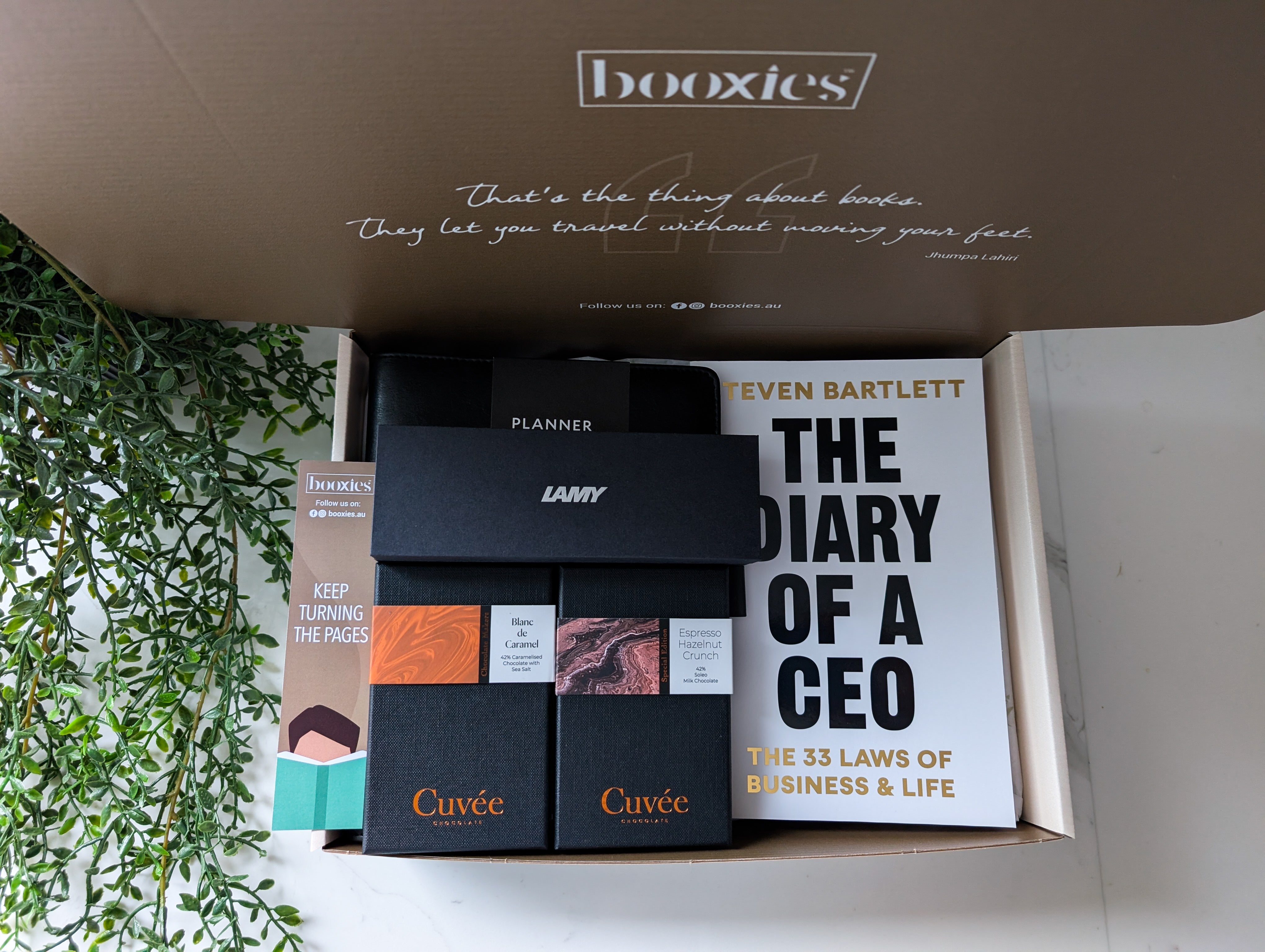 Box of stationery items including a planner, Lamy pen, and books with visible branding.