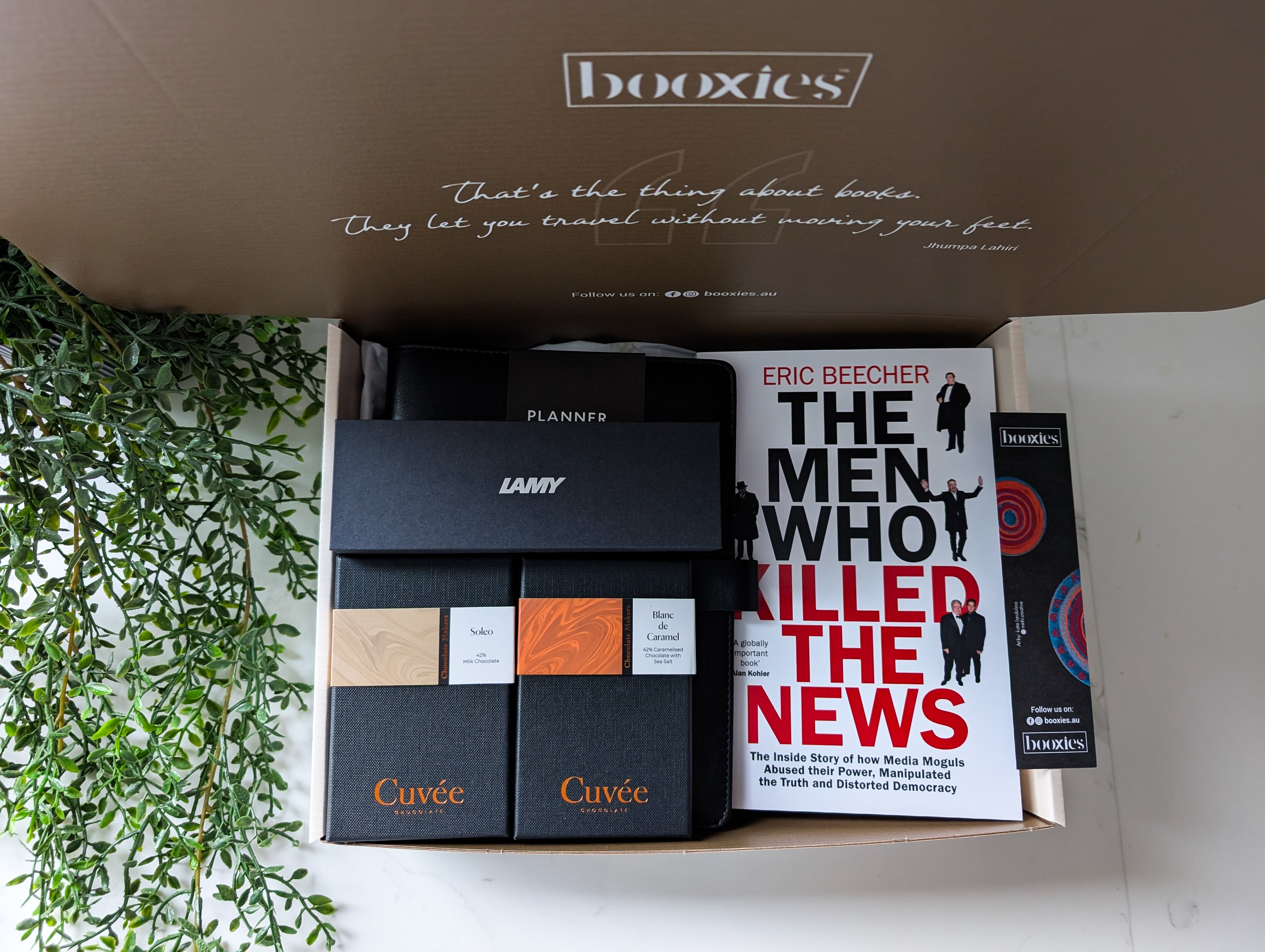 Box of stationery items including books and a planner with 'booxies' branding.