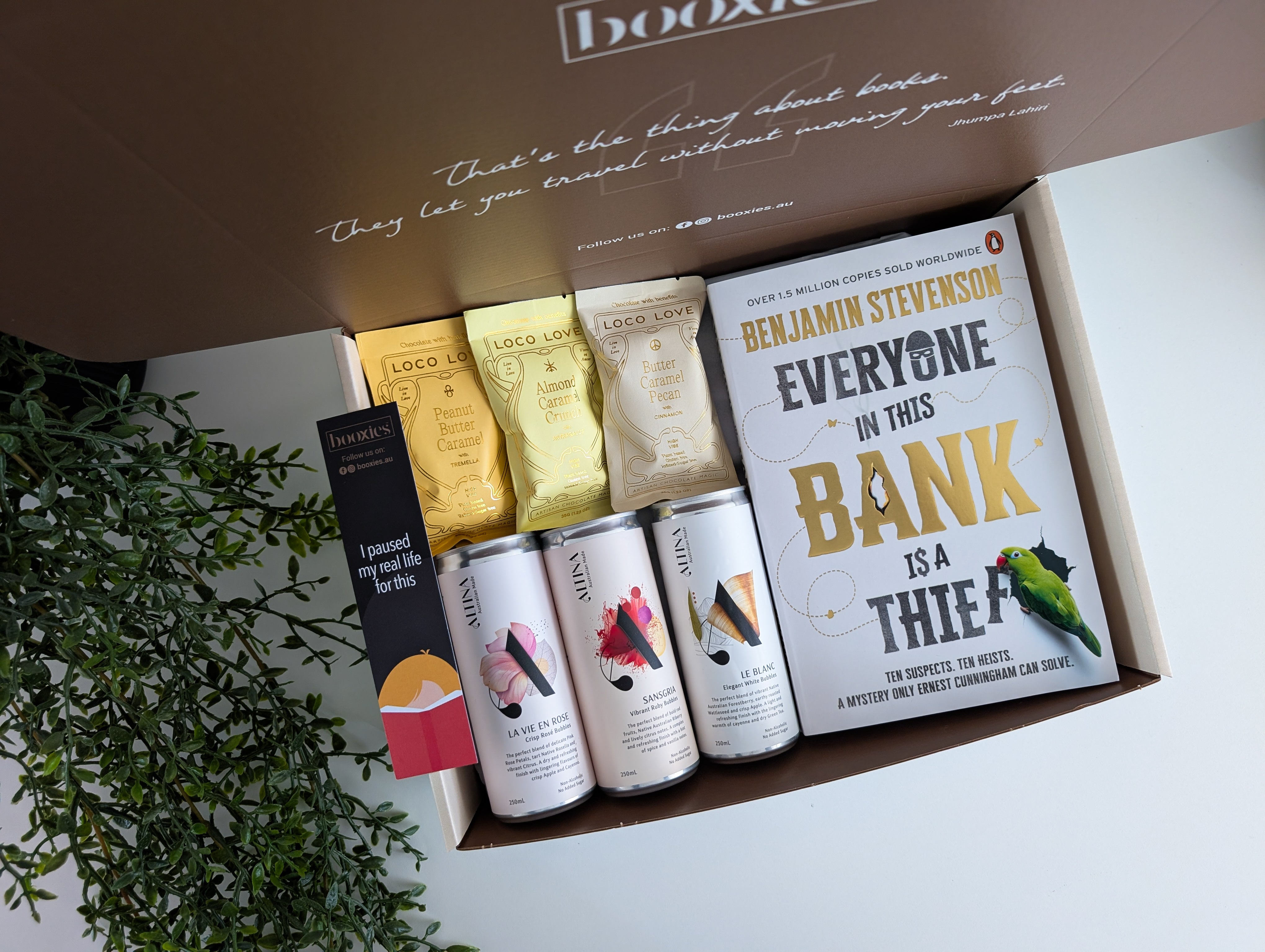 Box containing books and drinks with a plant in the background. summer spirit curated booxies