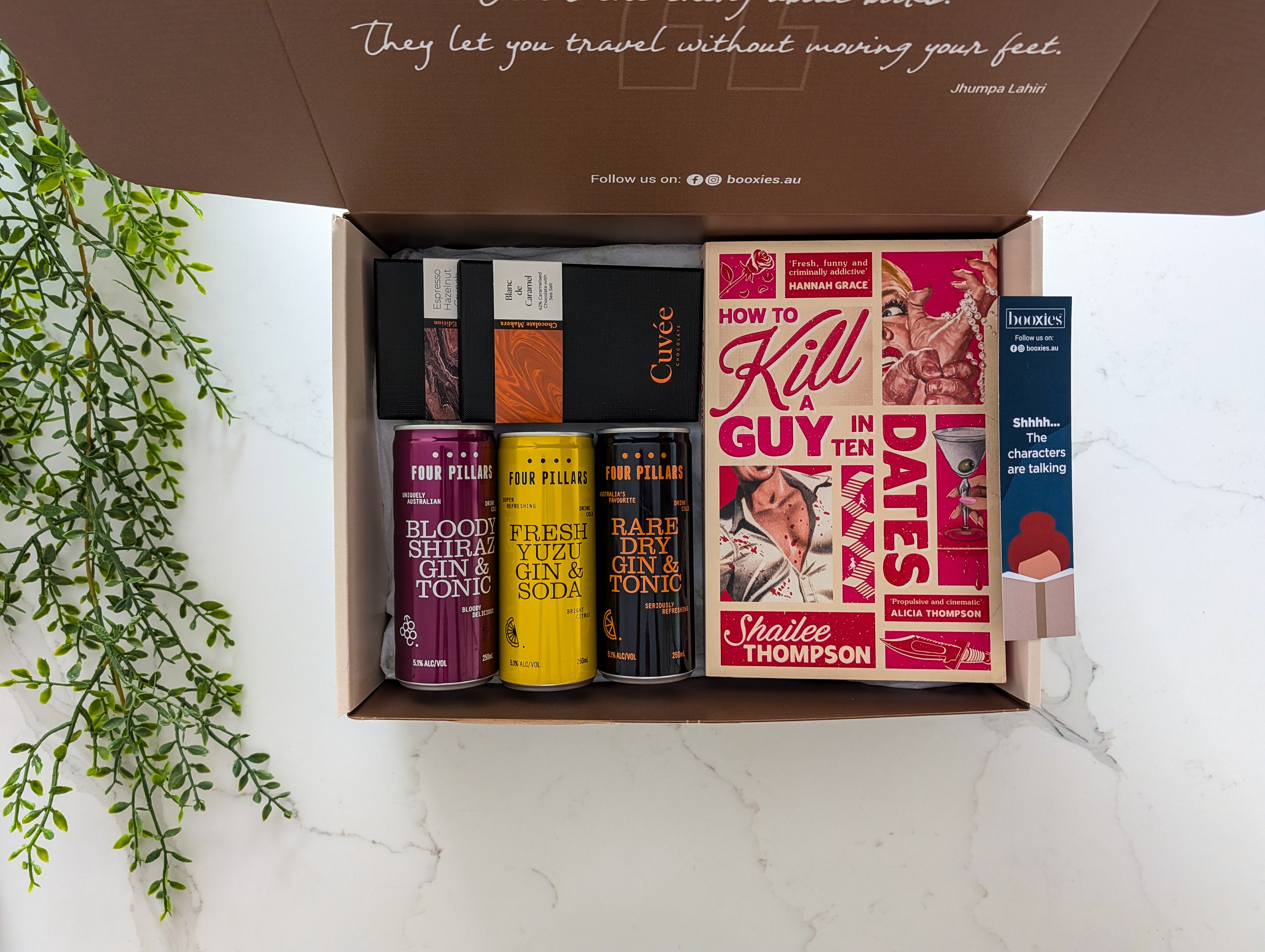 Open box containing books and drinks on a light background