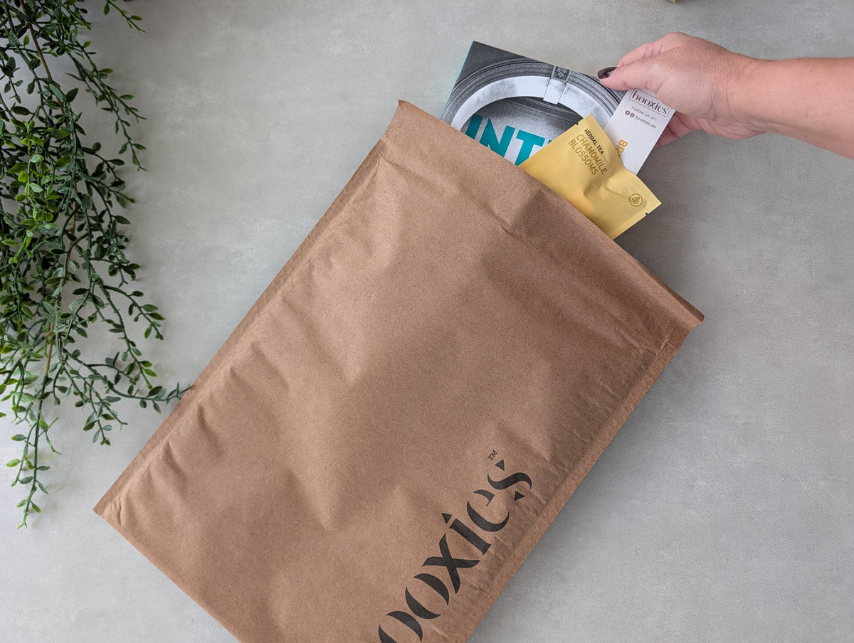 hand inserting a book Inter Alia into Essential Boxless Booxies subscription