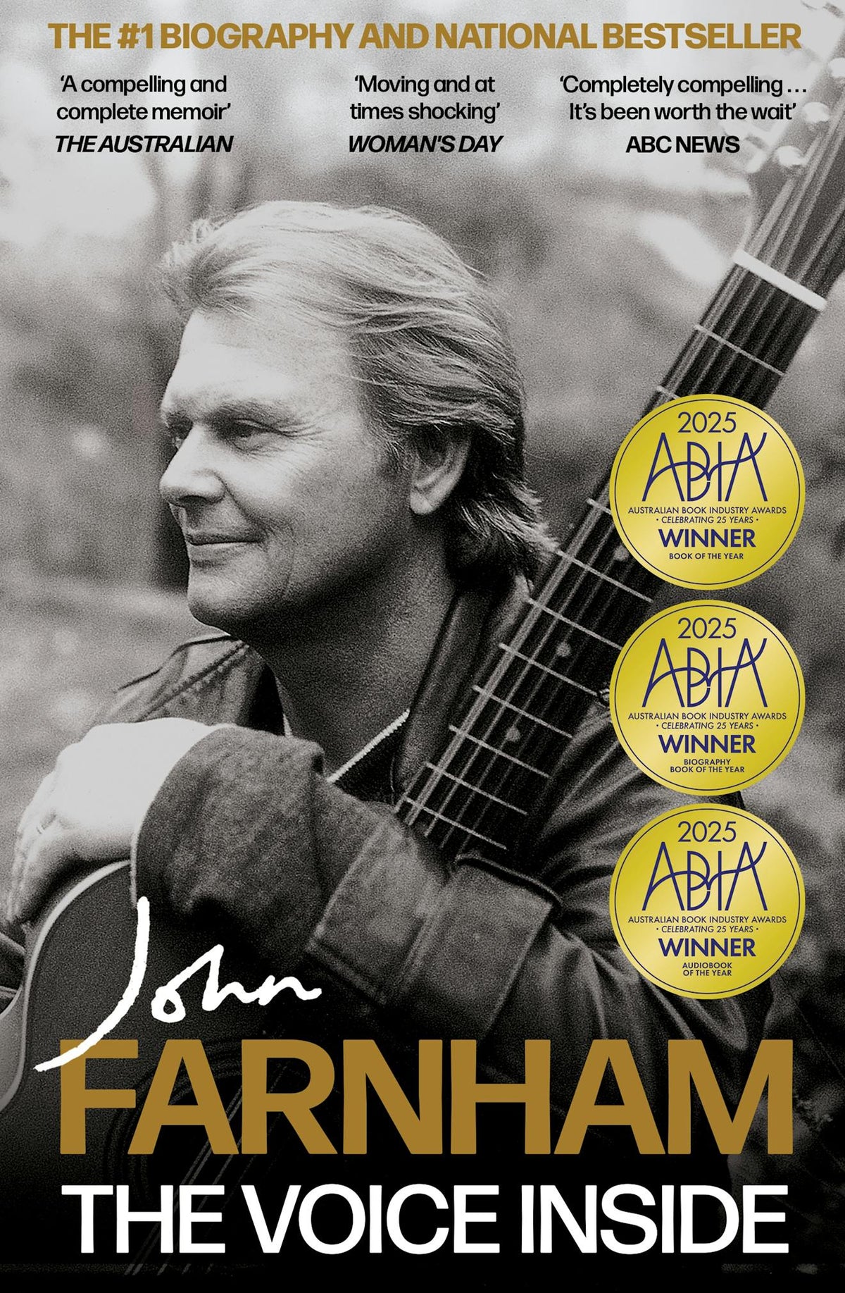 Book cover for 'The Voice Inside' by John Farnham, featuring a black-and-white portrait of a man holding a guitar, with gold and white typography and three gold ABBA award seals on the right.