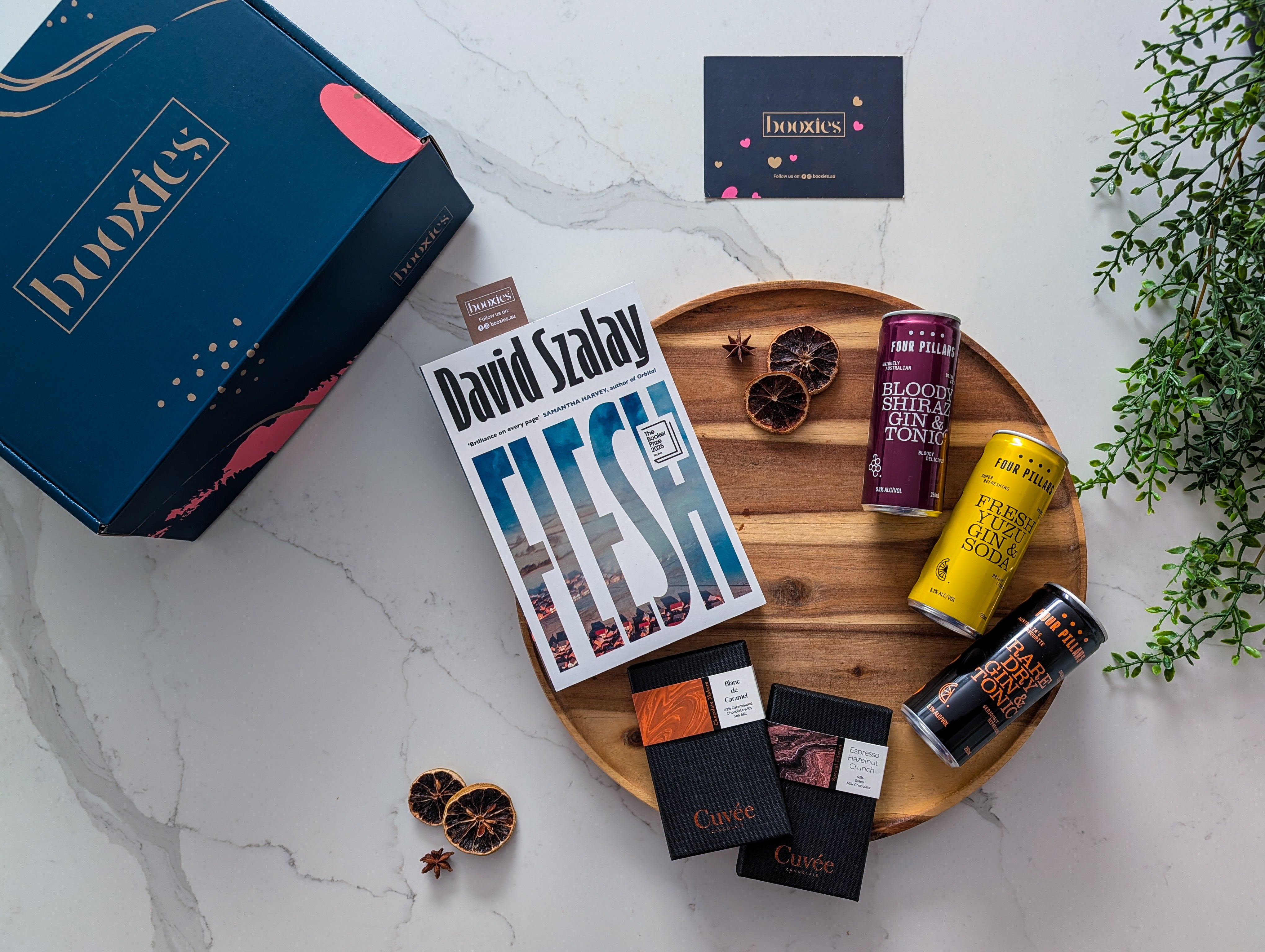 Flesh book on a wooden tray with 2 hand made chocolate from Cuvee and 3x g&T from Four Pilars and a booxies box making G&T Trio n Tale Curated Booxies