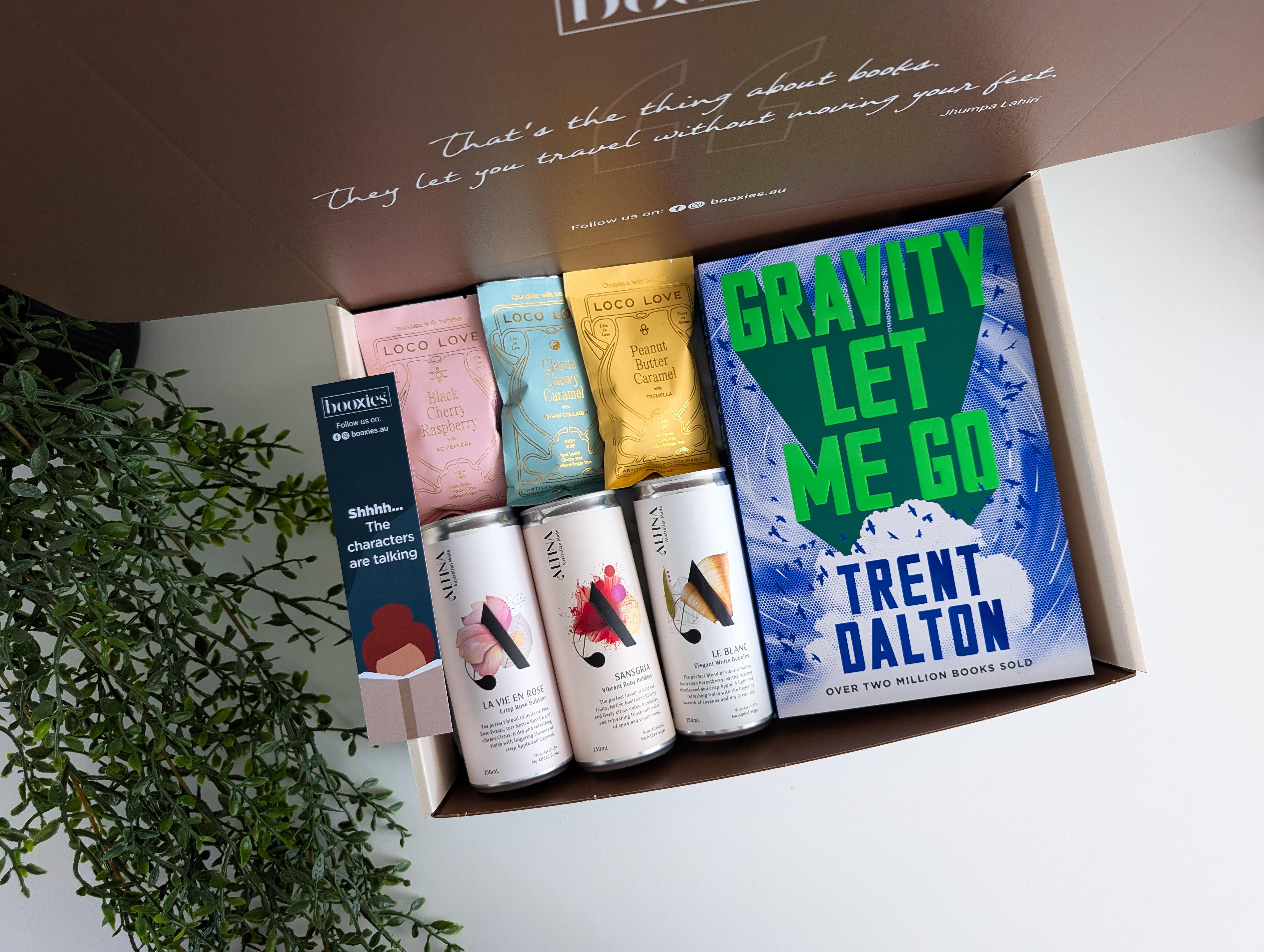 Box containing books and drinks with a plant in the background. summer spirit curated booxies