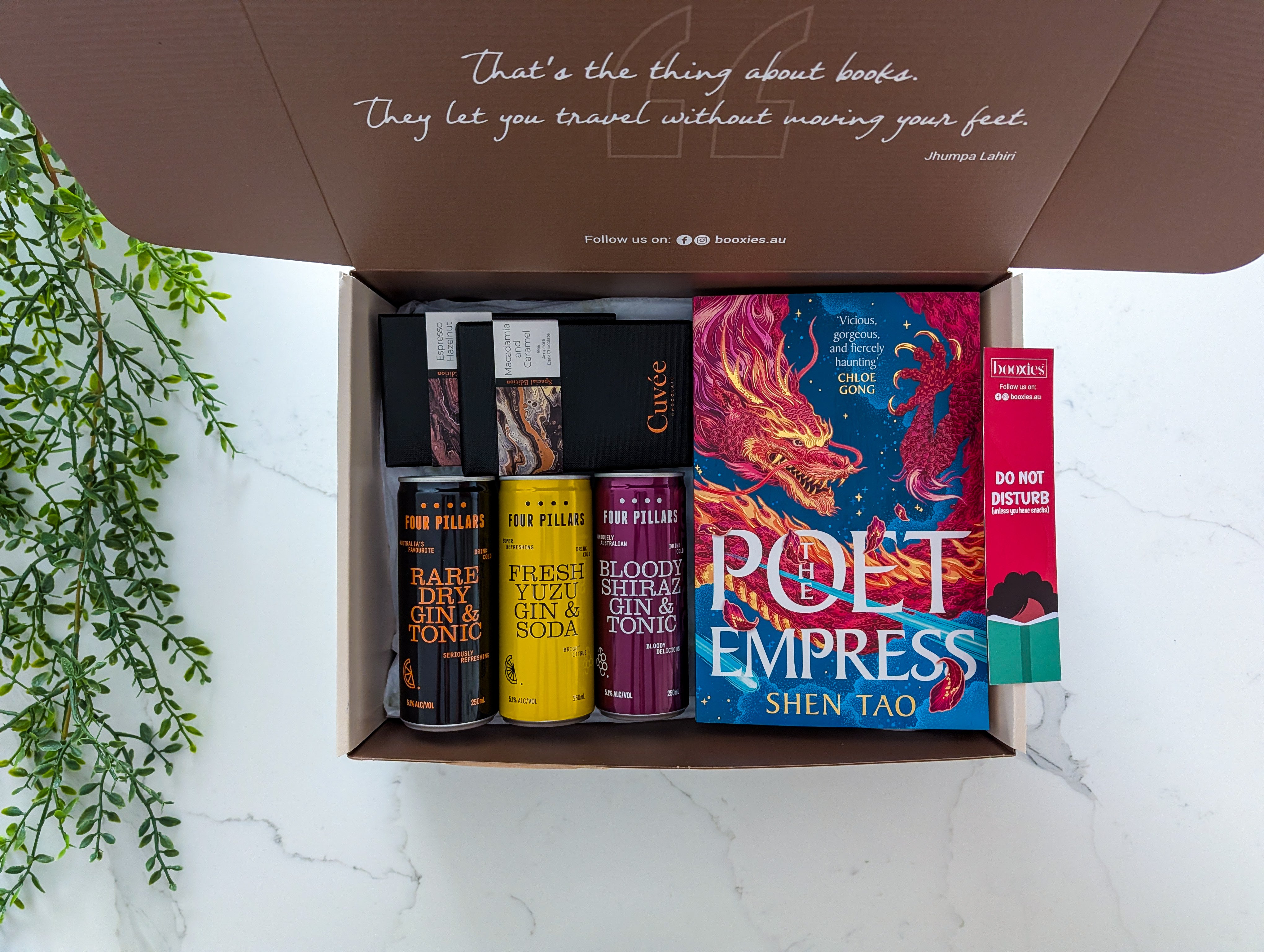 Open box containing books with a quote on the lid, on a light background.