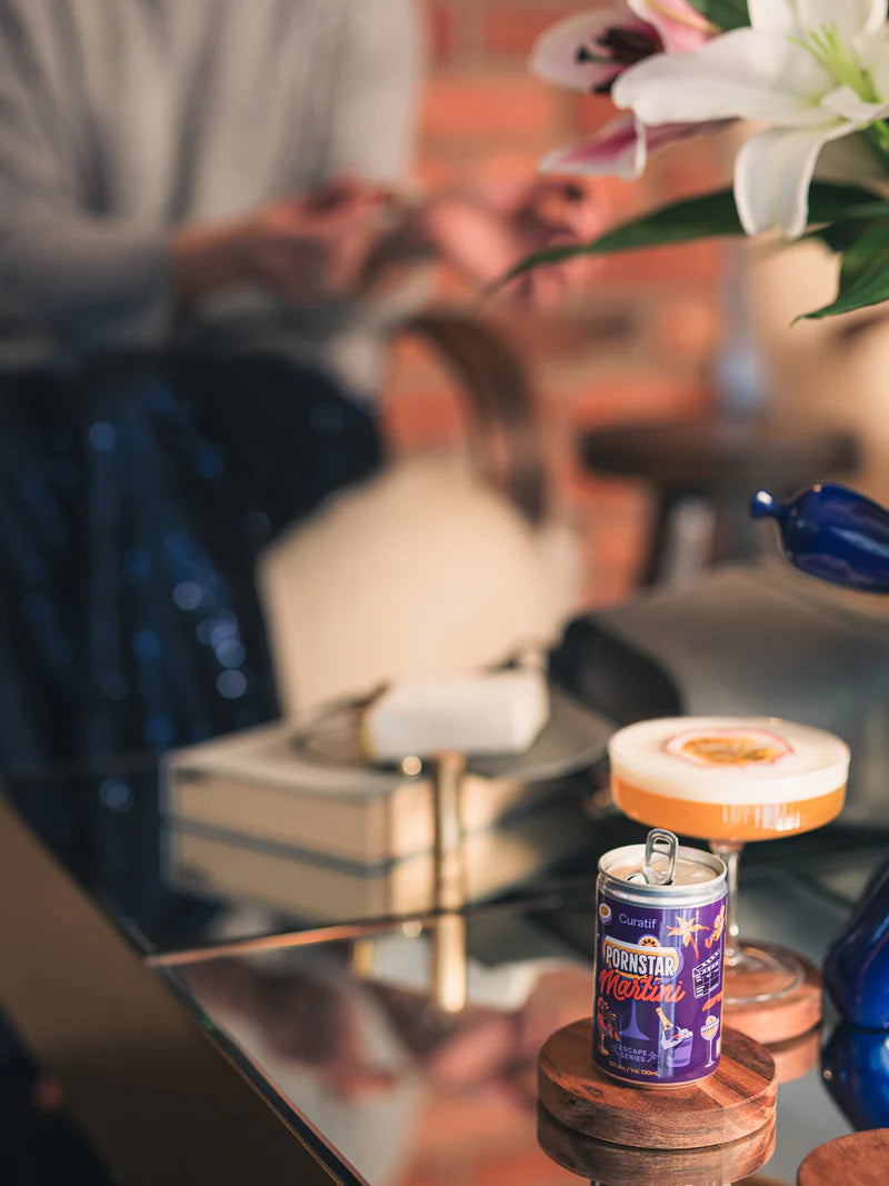 Close-up of a cocktail with a can on a table, blurred background
