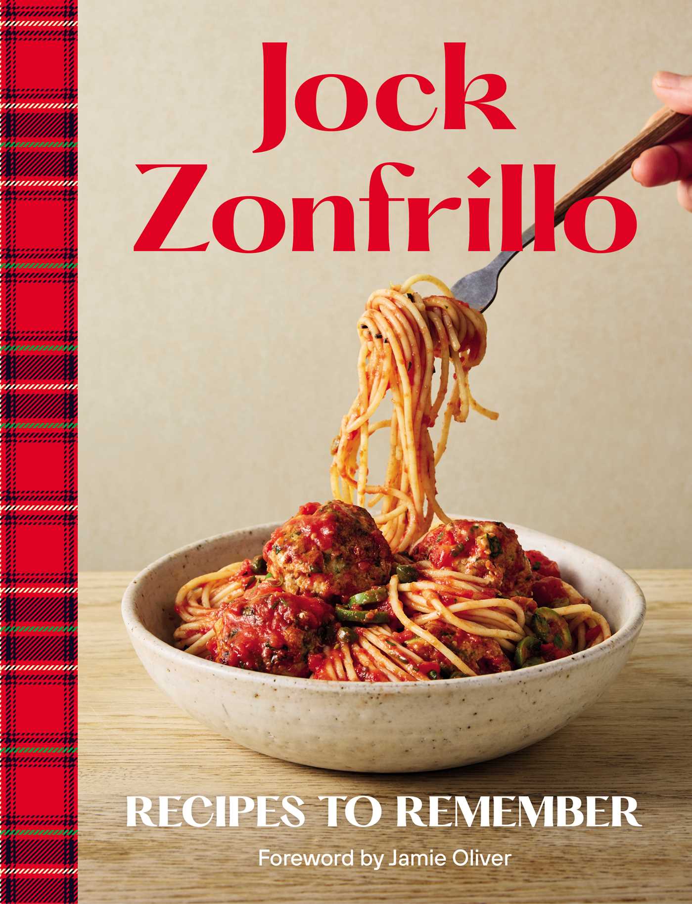 Cookbook cover with a bowl of spaghetti and meatballs, a fork, and a plaid border.