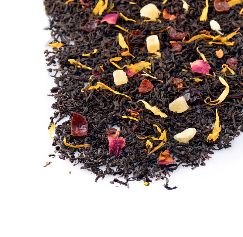 Black tea leaves with colorful floral and fruit pieces on a white background